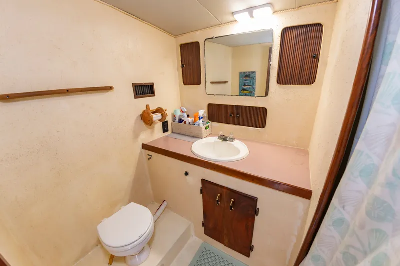 Slide: The Image of The image shows a boat bathroom with a toilet, sink, and mirror. - 39