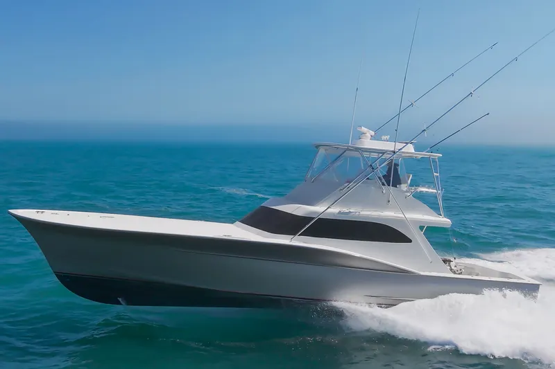 The Image of A sleek sportfishing boat speeds across the blue sea, equipped with multiple fishing rods. - 0