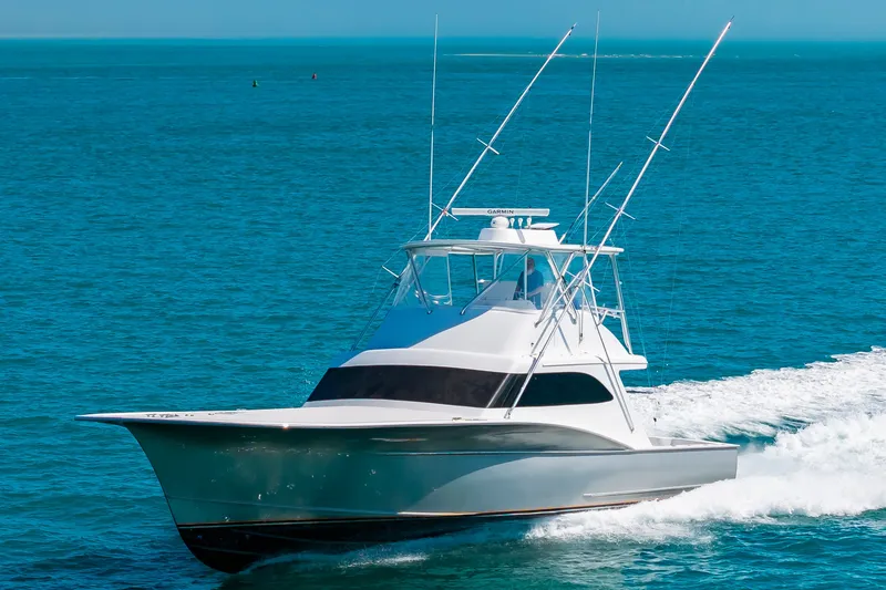 Slide: The Image of A sleek sportfishing boat speeds across the blue sea, featuring two tall fishing rods. - 8