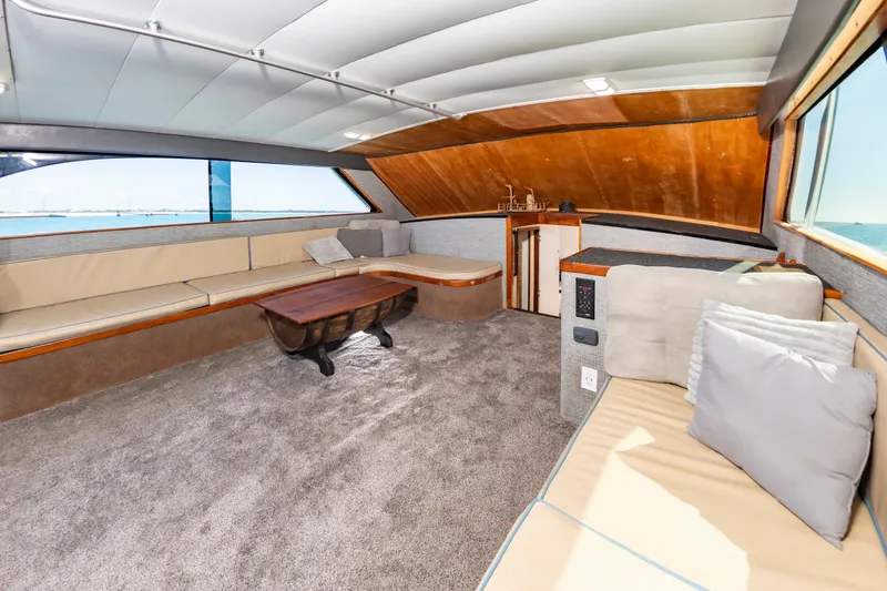 Slide: The Image of Interior of a 2000 Custom Carolina Terry Guthrie Sportfish with comfortable seating and a wooden table. - 21