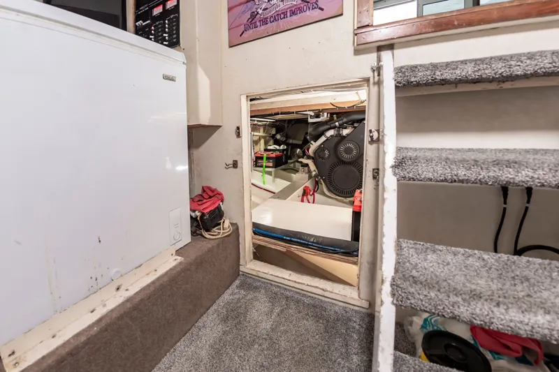Slide: The Image of An interior with carpeted flooring, a staircase, and access to an engine room. - 25