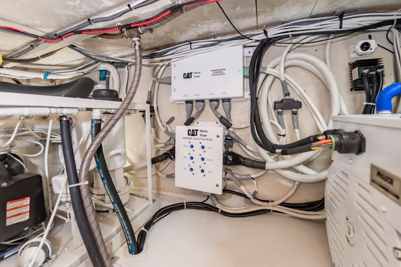 Slide: The Image of The engine room of a 2000 Custom Carolina Terry Guthrie Sportfish shows complex wiring and equipment. - 32