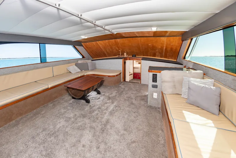 Slide: The Image of Interior of a 2000 Custom Carolina Terry Guthrie Sportfish with cozy seating areas and wooden table. - 20