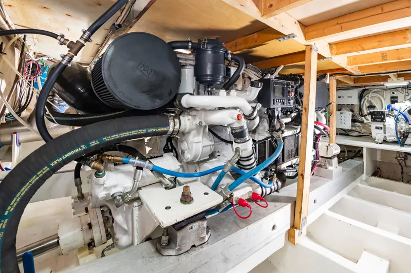 Slide: The Image of The engine room of a 2000 Custom Carolina Terry Guthrie Sportfish shows complex engines and wiring. - 36