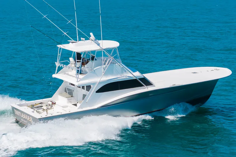 Slide: The Image of A 2000 Custom Carolina Terry Guthrie Sportfish cruising swiftly over the blue sea. - 5