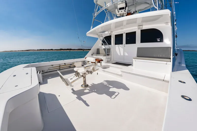 Slide: The Image of The boat is a 2000 Custom Carolina Terry Guthrie Sportfish. It features a spacious deck with seating and a fishing chair, ideal for sportfishing. - 11