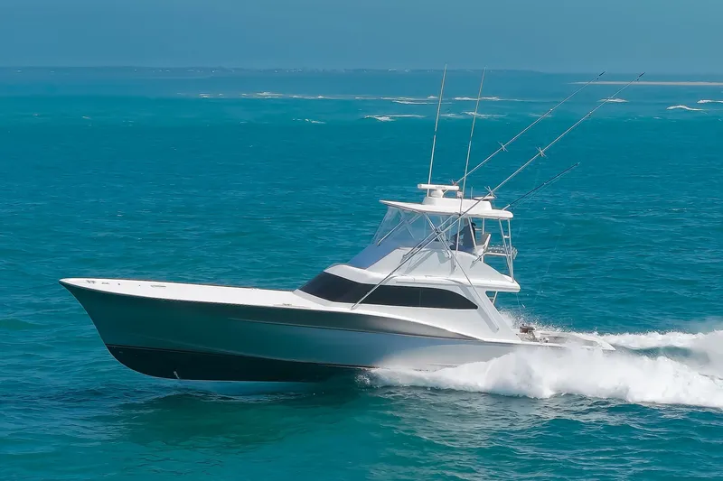 Slide: The Image of A sleek sportfishing boat speeds across the blue sea, equipped with multiple fishing rods. - 1