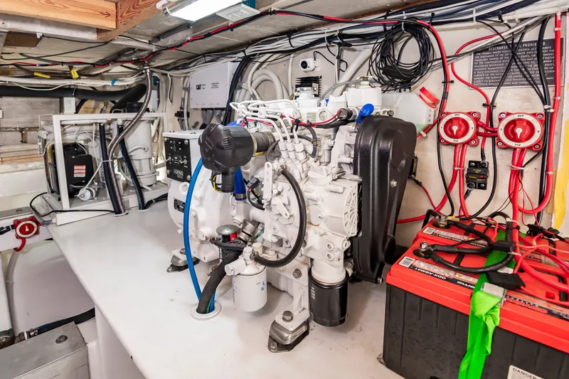 Slide: The Image of The engine room of a 2000 Custom Carolina Terry Guthrie Sportfish features an engine and electrical wiring. - 34