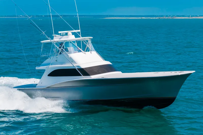 Slide: The Image of A sleek sportfishing boat speeds across the blue sea, with a clear, sunny coastline in the background. - 6