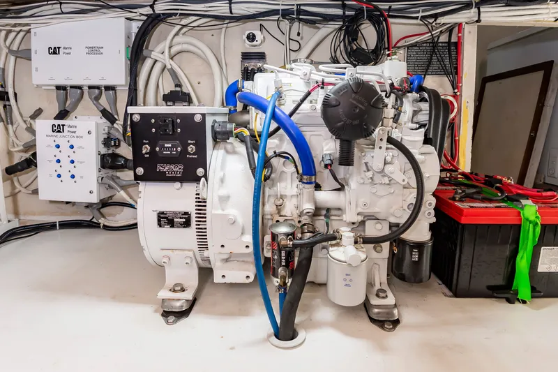 Slide: The Image of A clean engine room with a generator and electrical connections, surrounded by cables and control boxes. - 33