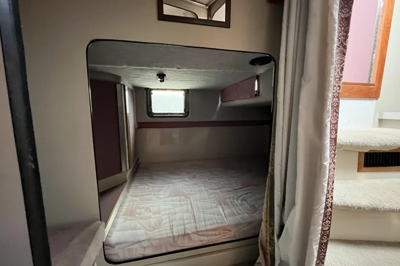 Slide: The Image of 1987 Carver 2757 Montego cabin interior with bed, window, and stairs. - 4