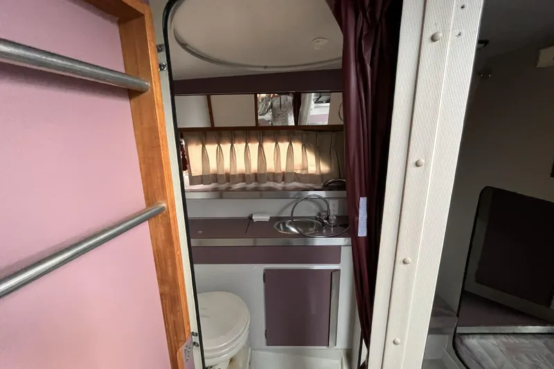 Slide: The Image of Interior of 1987 Carver 2757 Montego boat, featuring compact bathroom and sink area. - 5