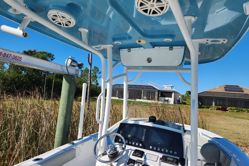 Slide: The Image of 2020 Sportsman Open 232 Center Console boat with blue T-top and modern dashboard. - 11
