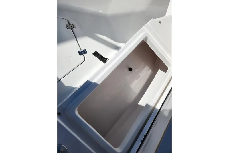 Slide: The Image of 2020 Sportsman Open 232 Center Console storage compartment, white interior, open lid. - 19