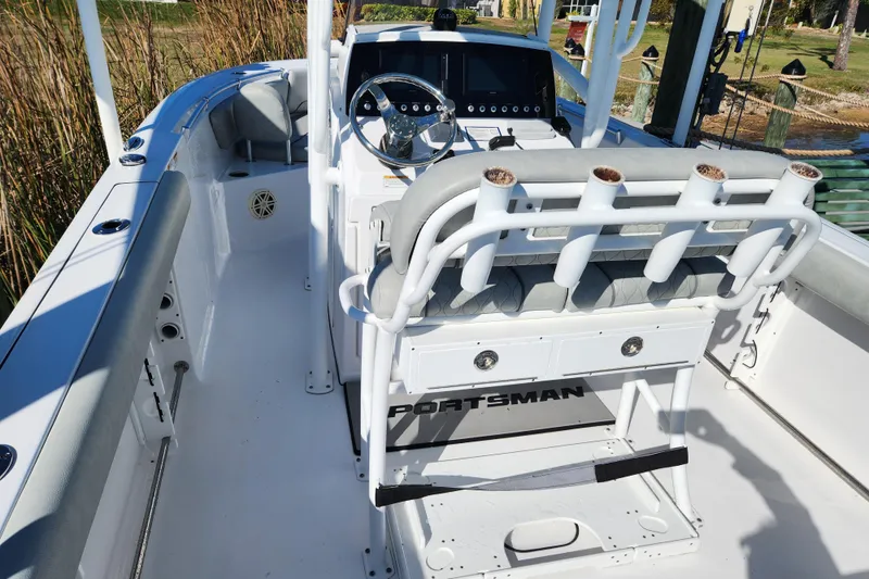 Slide: The Image of 2020 Sportsman Open 232 Center Console boat interior with steering wheel and rod holders. - 2