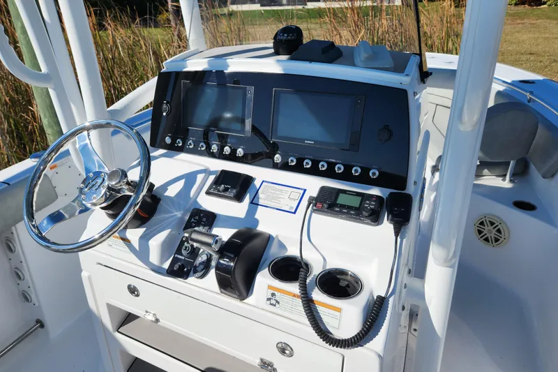 Slide: The Image of 2020 Sportsman Open 232 Center Console boat dashboard with steering wheel and navigation equipment. - 7