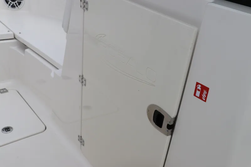 Slide: The Image of Storage compartment of 2026 Robalo R257 Dual Console boat, open with black mats. - 42