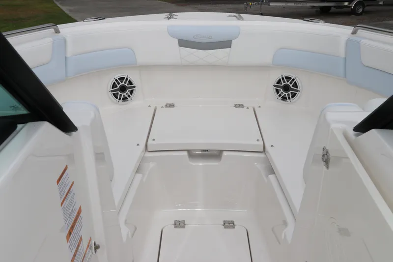Slide: The Image of 2026 Robalo R257 Dual Console storage compartment with fire extinguisher symbol. - 43