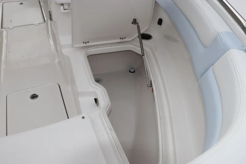 Slide: The Image of 2026 Robalo R257 Dual Console boat interior with storage compartment and fire extinguisher symbol. - 46
