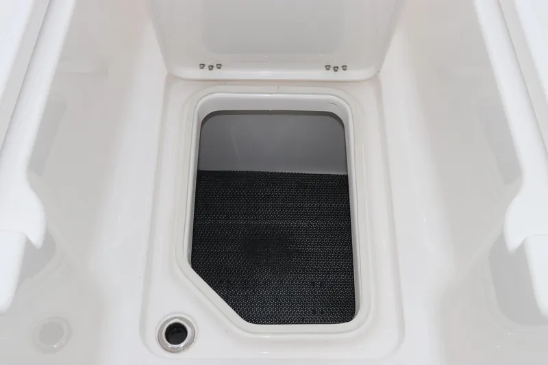 Slide: The Image of Storage compartment of 2026 Robalo R257 Dual Console boat, featuring a clean, white interior. - 58