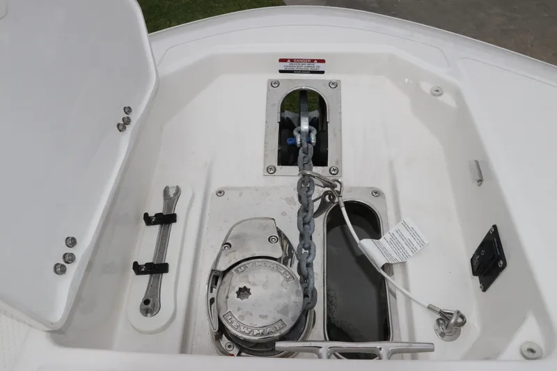 Slide: The Image of Anchor compartment of 2026 Robalo R257 Dual Console boat, featuring chain and winch. - 60