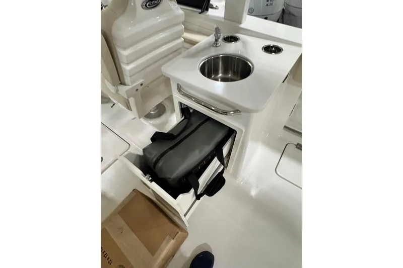 Slide: The Image of 2026 Robalo R257 Dual Console interior with sink and storage compartment. - 9