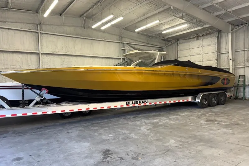 Slide: The Image of 2018 Cigarette 42X powerboat in a garage, yellow and black, on a Blue Fin trailer. - 2
