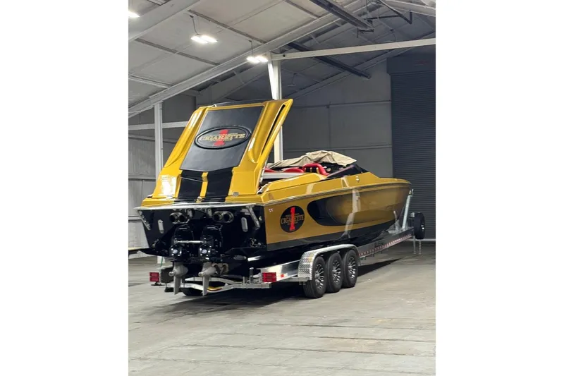 Slide: The Image of 2018 Cigarette 42X powerboat in a warehouse, gold and black design on trailer. - 4