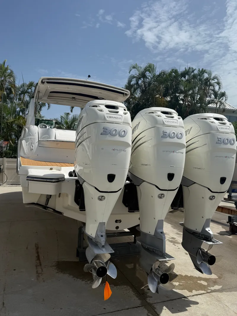 Slide: The Image of A 2018 Sea Ray SLX 350 Outboard with three powerful outboard engines, parked at a dock. - 25