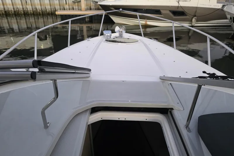 Slide: The Image of 2023 Regal 26 XO boat deck view at marina, showcasing sleek design and railing. - 7