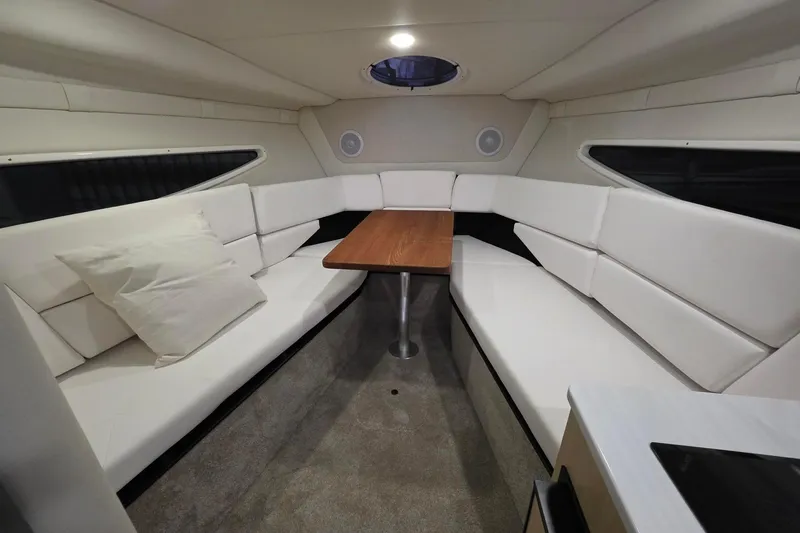 Slide: The Image of Luxurious interior of 2023 Regal 26 XO boat with white seating and wooden table. - 8