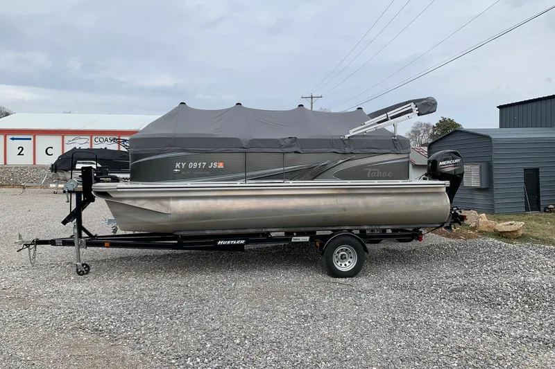 The Image of 2020 Tahoe Pontoon Sport Cruise Rear Bench 18' on trailer, covered and parked outdoors. - 0