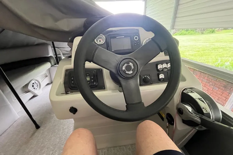 Slide: The Image of 2020 Tahoe Pontoon Sport Cruise Rear Bench 18' steering console with controls and dashboard. - 7