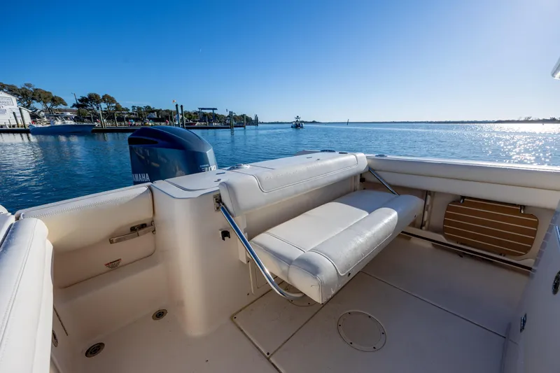 Slide: The Image of 2018 Grady-White Fisherman 236 boat interior with Yamaha engine, docked by serene waters. - 17