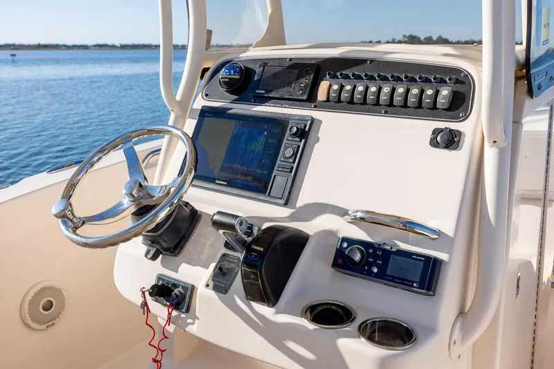 Slide: The Image of 2018 Grady-White Fisherman 236 boat dashboard with steering wheel and navigation controls. - 22