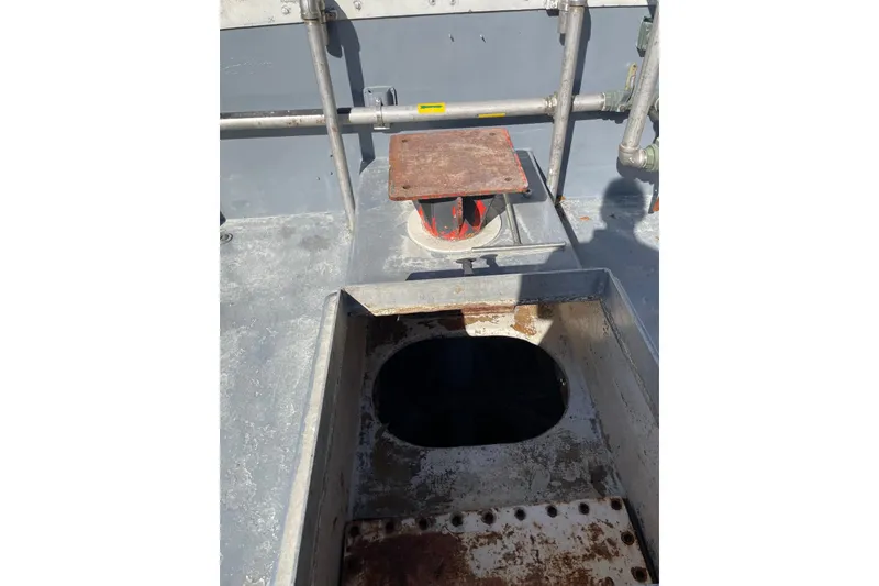 Slide: The Image of 1987 Commercial Buoy Tender deck with open hatch and metal structures. - 13