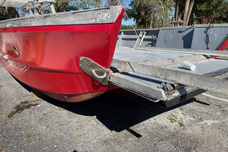 Slide: The Image of Red 1987 commercial buoy tender with metal deck, parked on gravel. - 20