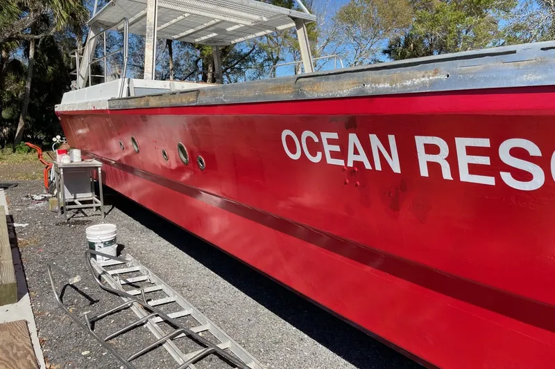 Slide: The Image of Red 1987 Commercial Buoy Tender "Ocean Res" on land, with maintenance equipment nearby. - 21