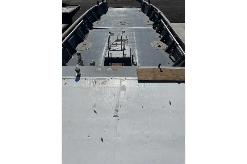 Slide: The Image of 1987 Commercial Buoy Tender deck with metal railings and hatches, viewed from above. - 23