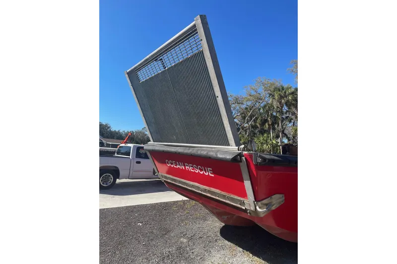 Slide: The Image of Red buoy tender with "Ocean Rescue" text, 1987 model, parked near trees and a truck. - 26