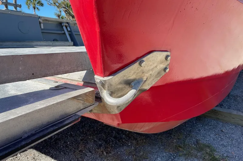 Slide: The Image of Red 1987 commercial buoy tender hull with metal fittings on a trailer. - 6