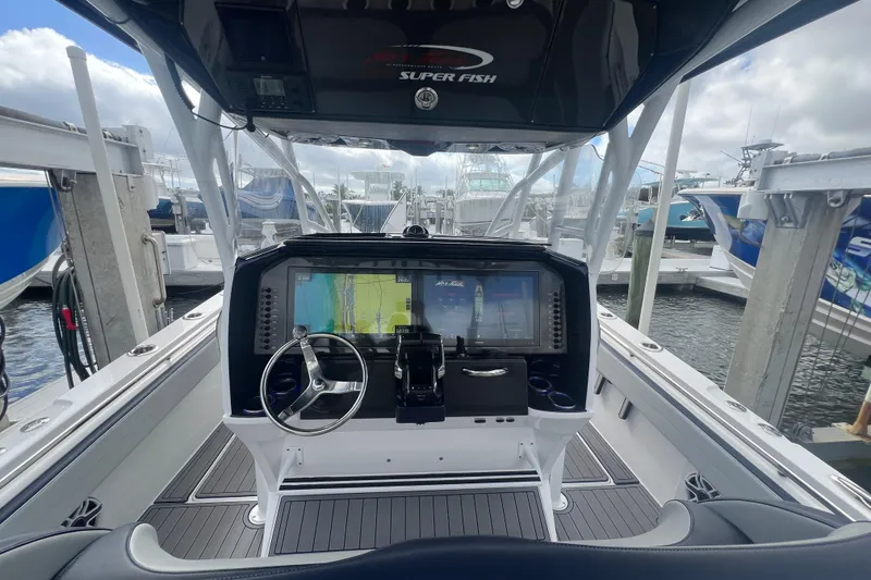 Slide: The Image of 2024 Nor-Tech 392 Super Fish boat dashboard with advanced navigation system at marina. - 2