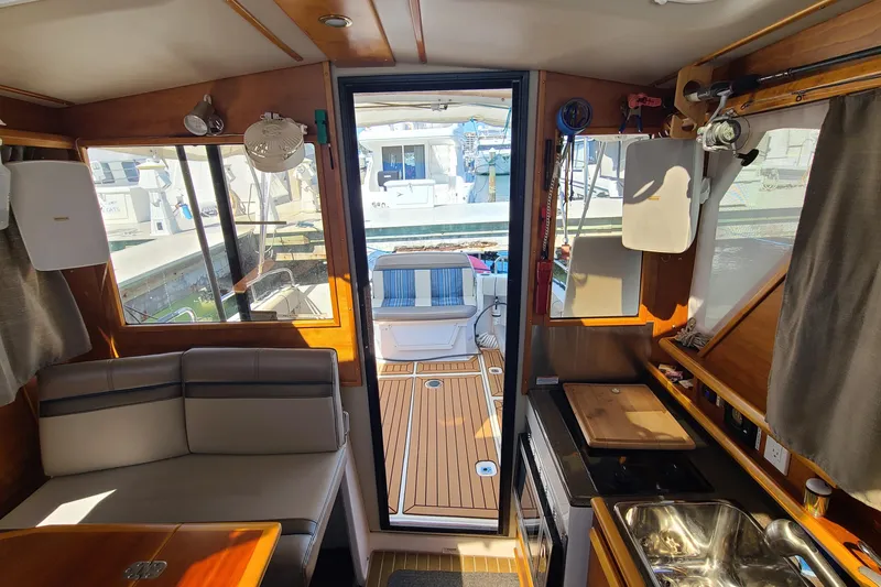 Slide: The Image of Interior of a 2019 Cutwater C-28 LE boat, featuring seating and kitchenette. - 12