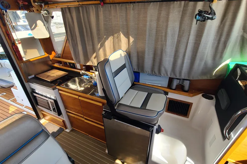 Slide: The Image of 2019 Cutwater C-28 LE interior with kitchenette, sink, and seating area. - 13