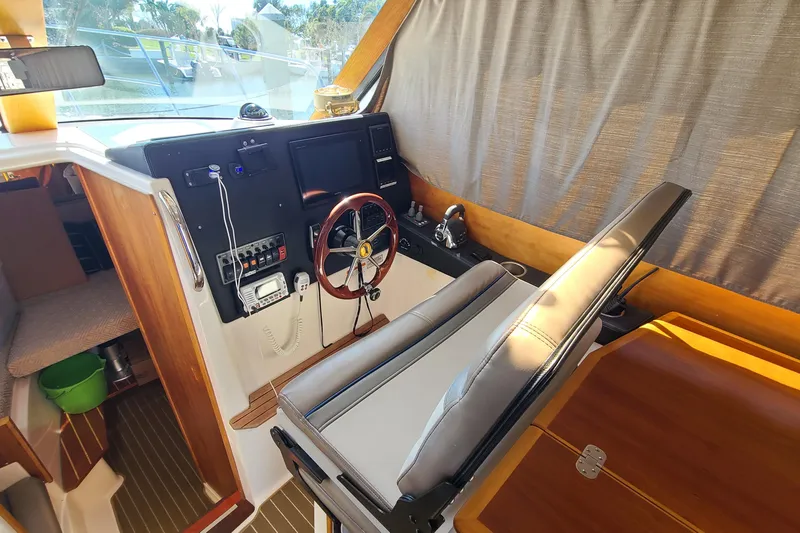 Slide: The Image of 2019 Cutwater C-28 LE helm with steering wheel, controls, and navigation equipment. - 15