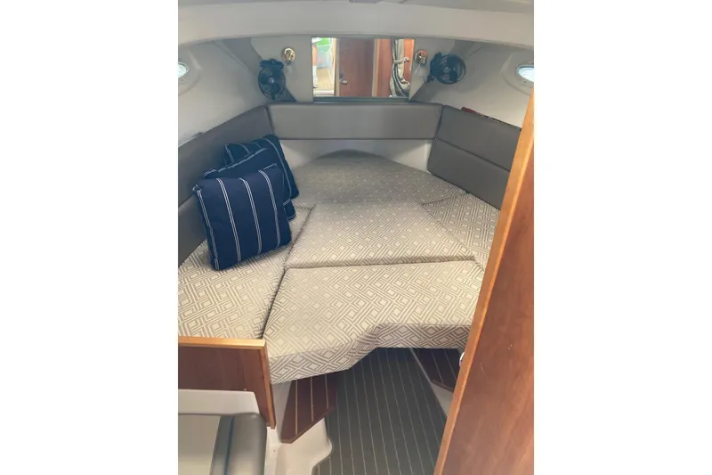 Slide: The Image of 2019 Cutwater C-28 LE cabin interior with bed and striped pillows. - 37