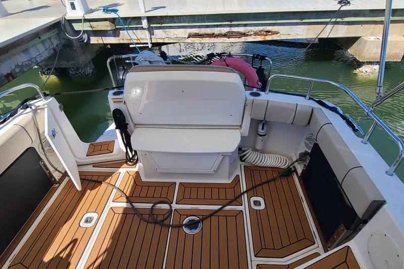 Slide: The Image of 2019 Cutwater C-28 LE boat interior with teak flooring and dock view. - 6