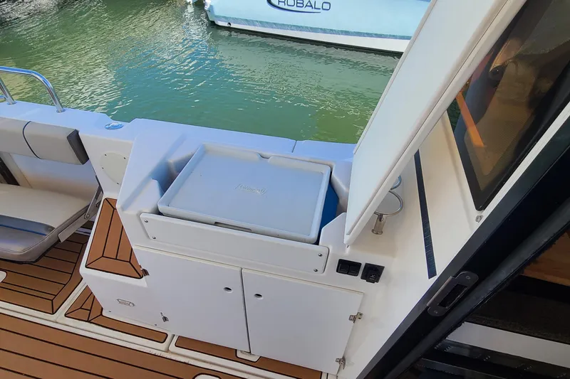 Slide: The Image of 2019 Cutwater C-28 LE boat interior with seating and storage, docked on calm water. - 8