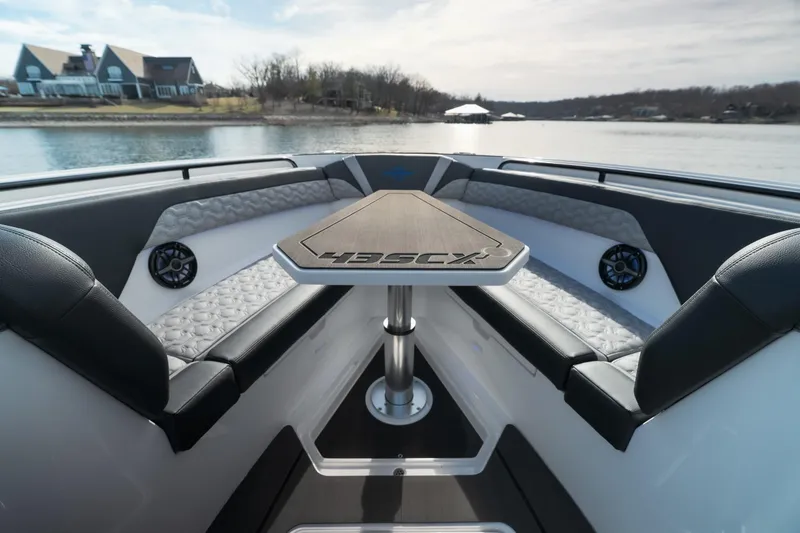 Slide: The Image of 2025 Fountain 43 SCX boat interior with sleek seating and table on a calm lake. - 27