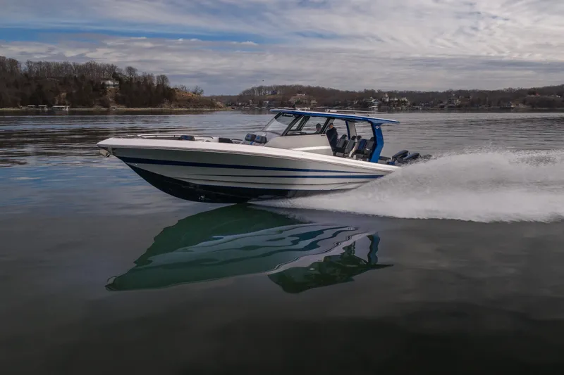 Slide: The Image of 2025 Fountain 43 SCX speedboat cruising on a calm lake under a cloudy sky. - 5
